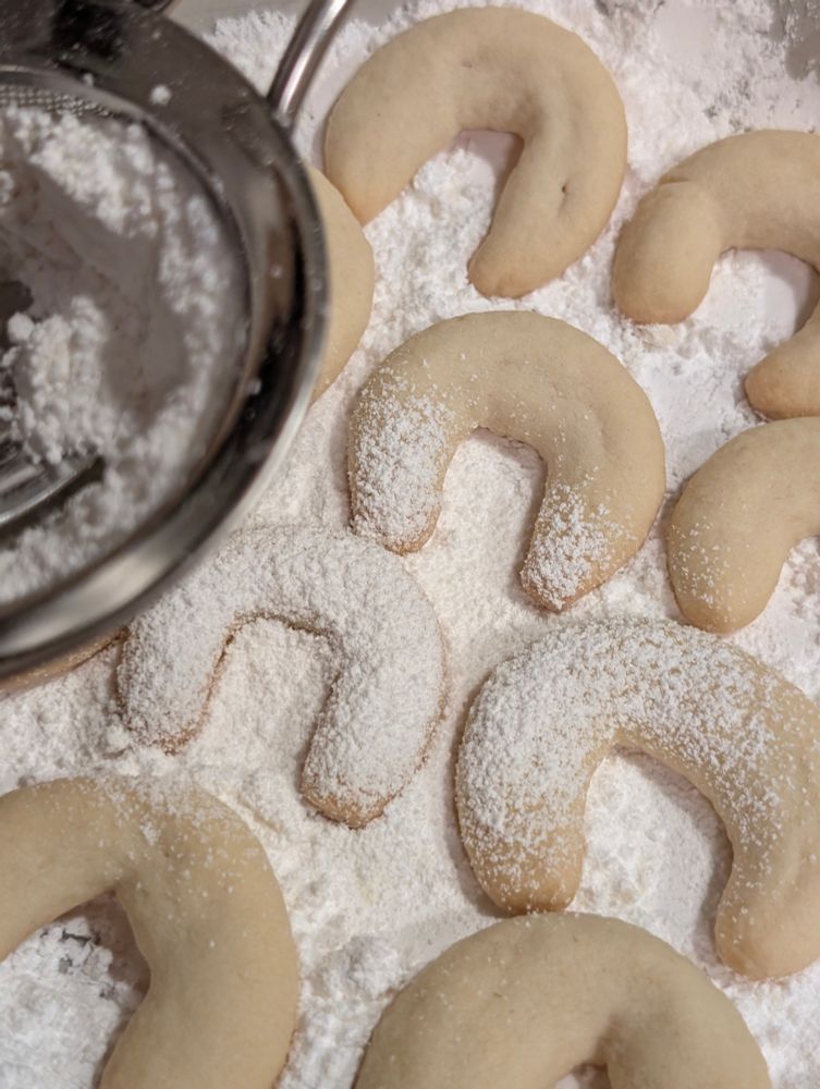 gebackene vanillekipferl bei der bestäubung mit zucker