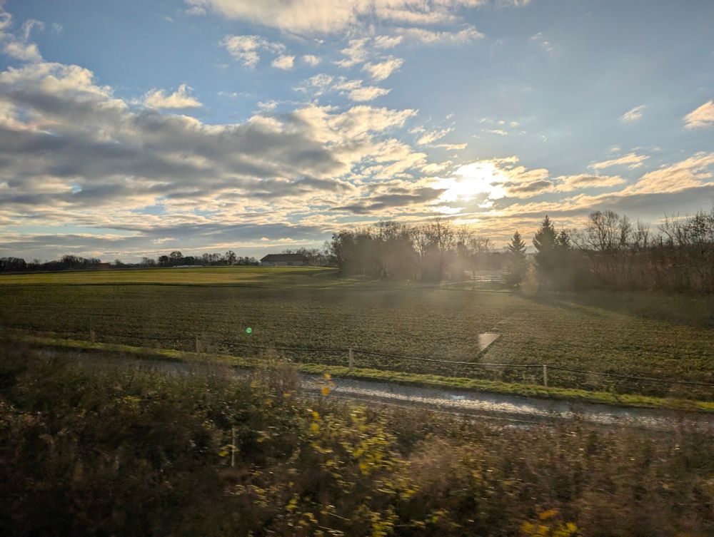 sonne mit leichten wolken über felder