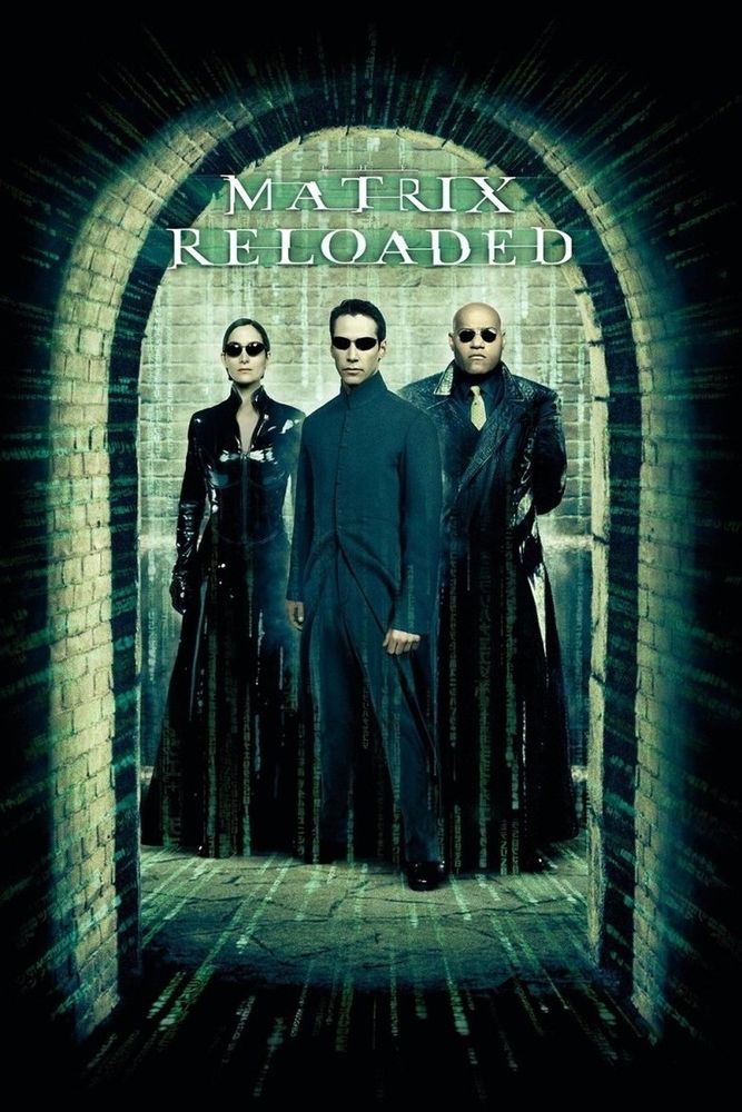 A woman and two men standing in an arched brick corridor. They're wearing black outfits including leather and PVC trenchcoats, a long black coat and sunglasses. There is green code flowing around them along the floors and walls. At the top is the movie's title "Matrix Reloaded"