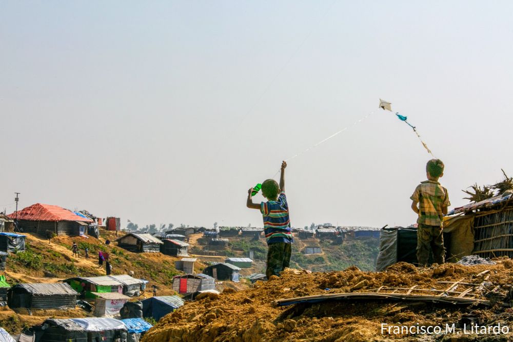 Two Rohingya boys, residents of the Kutupalong Refugee Camp in Ukhia, Cox's Bazar, Bangladesh, entertain themselves flying a kite.