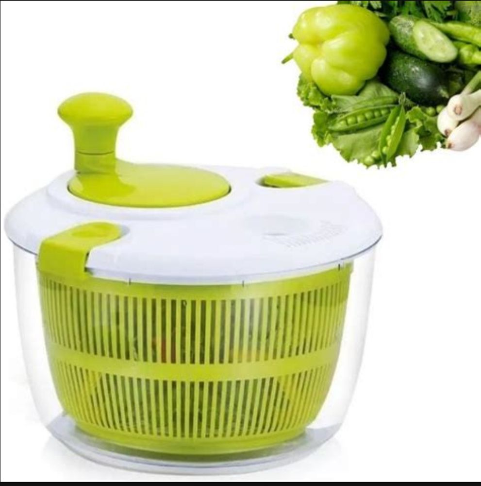 Uma foto de uma centrífuga de folhas ver e branca em um fundo branco, com legumes verdes no canto superior