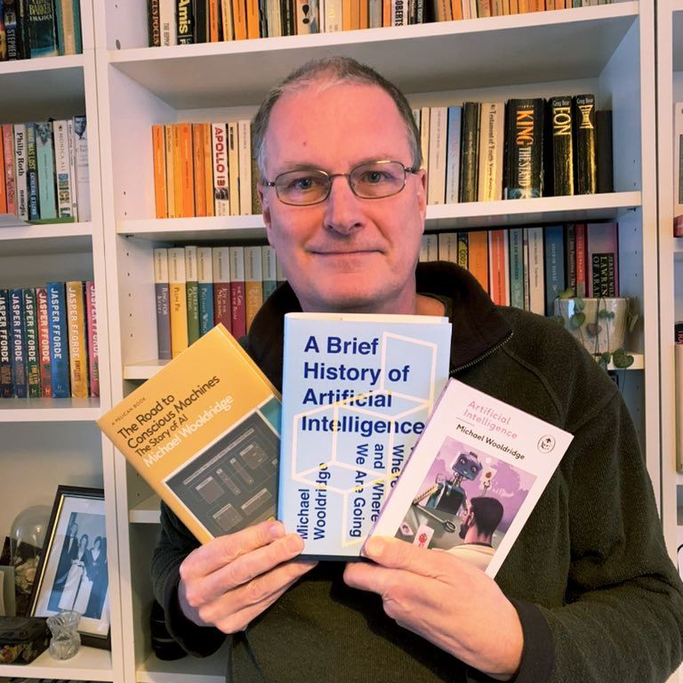 Author Michael Wooldridge holding 3 of his books including A Brief History of Artificial Intelligence