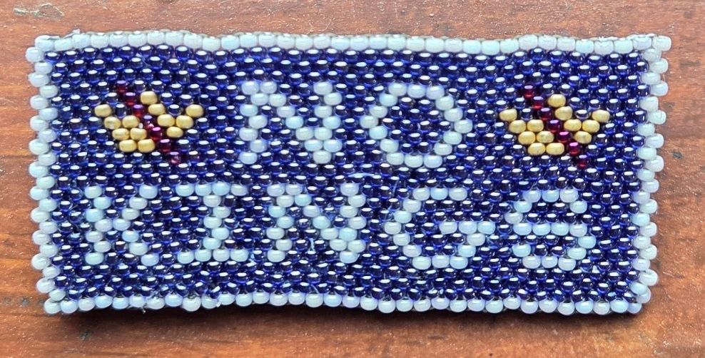 A beaded pin that says No Kings