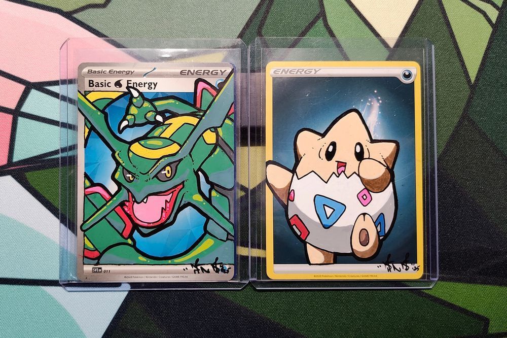Two Pokemon TCG energy cards with Rayquaza and Togepi painted on them with paint markers and ink liners.