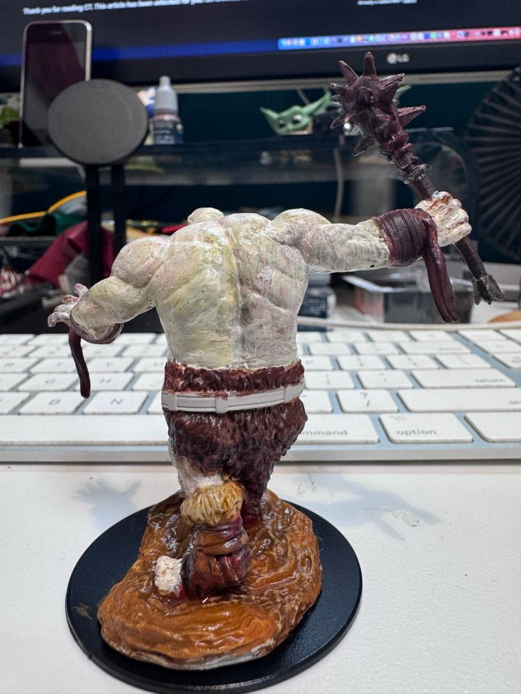 An ogre zombie miniature that’s partially painted. 