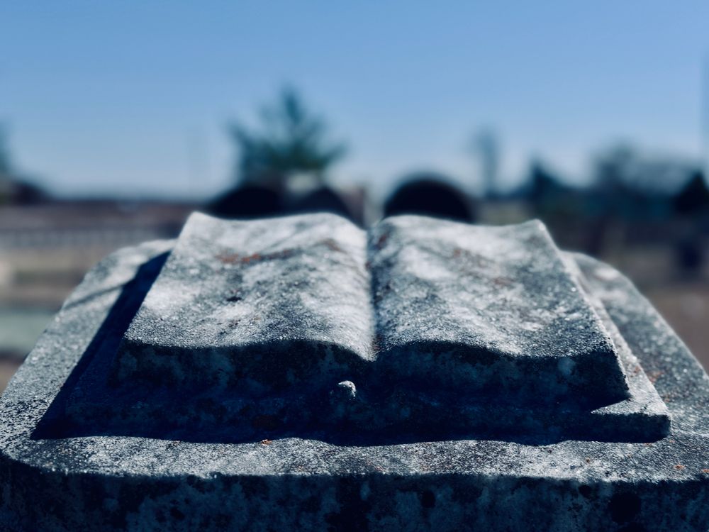 An open book/bible carved out of stone. 