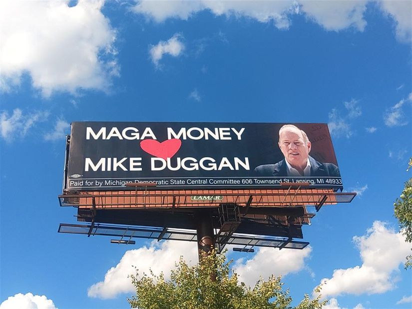 photo of a billboard with a beautiful blue sky spotted with clouds behind it. Billboard has an image of Mike Duggan looking like a sellout with the text

Maga Money
(heart)
Mike Duggan