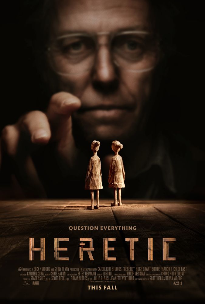 Movie poster for Heretic. In background is a man with glasses reaching forward to two wooden girl figures. 