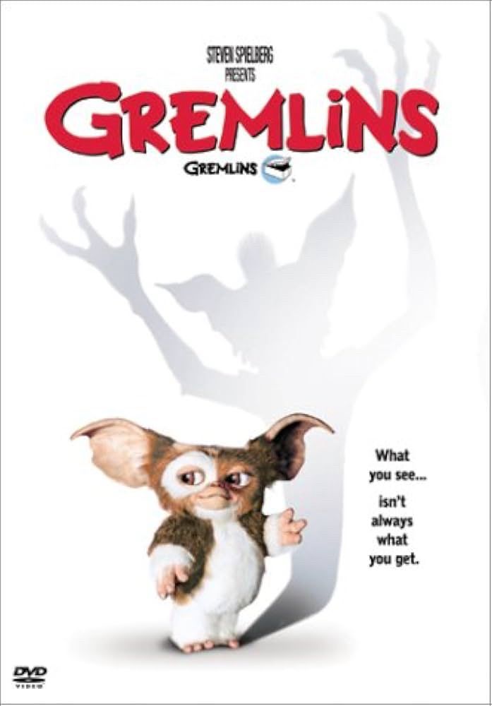Movie poster for Gremlins, small furry creature with a shadow of a larger scarier creature