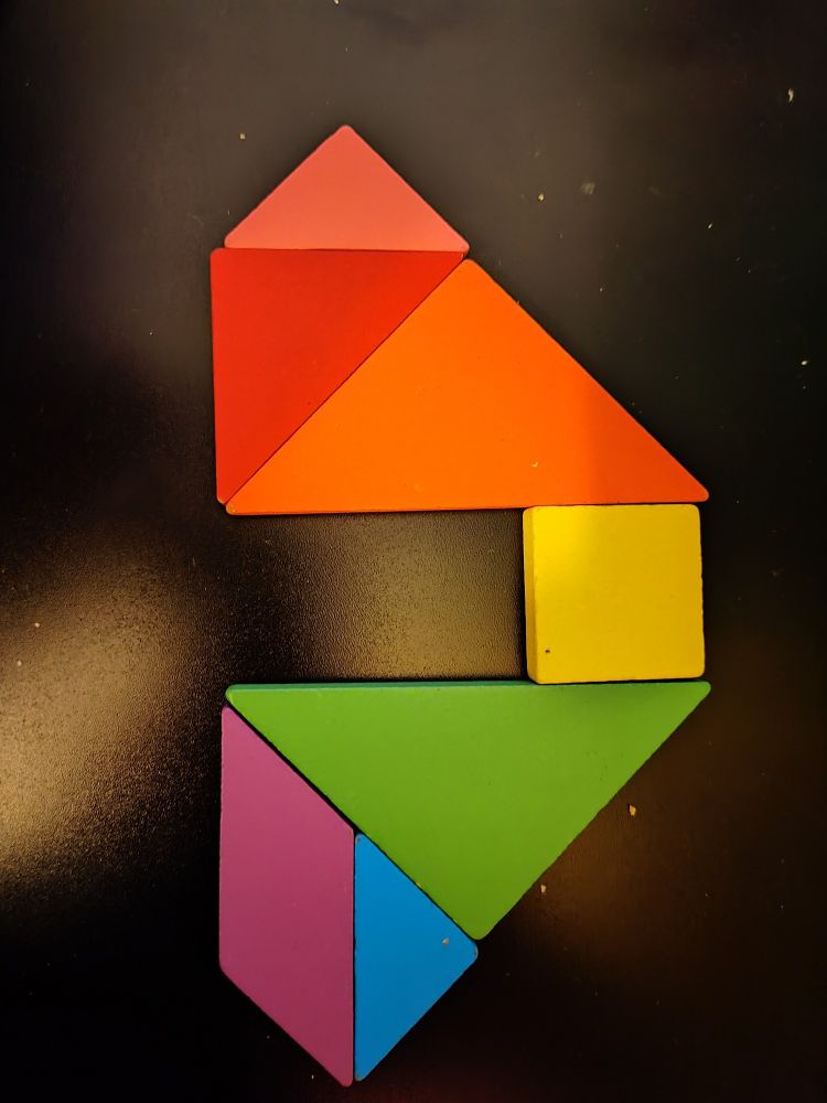 Blocks of different shapes arranged in a way to make a symmetrical shape, arranged pink/ red to purple