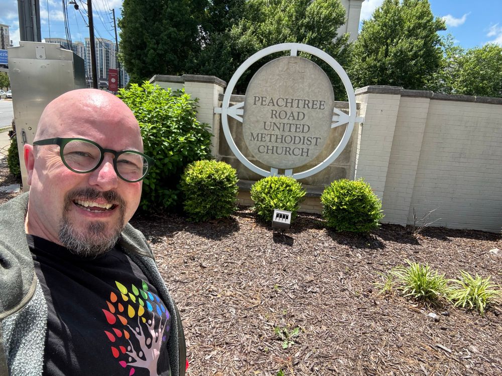 Me, squinting in front of the sign for Peachtree Rd UMC 