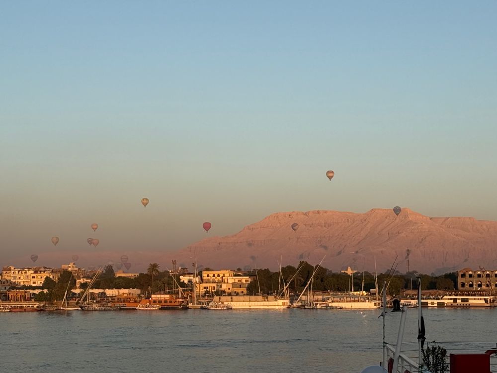 Hot air balloons reflecting the sunrise over the Nile River 