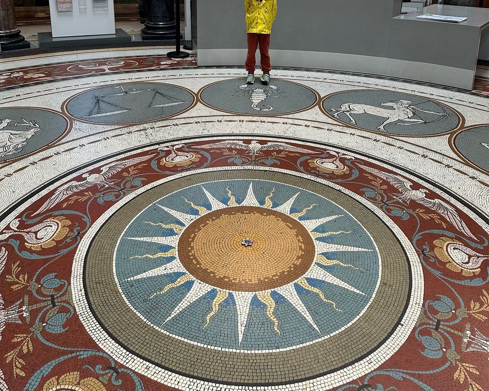 A photo of the scene. The Monica if is radially symmetrical with a representation of the Sun at the center. Orin is watching from the scorpion symbol. 