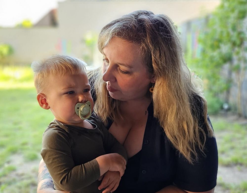 Me with my son on my lap sitting outside in our backyard