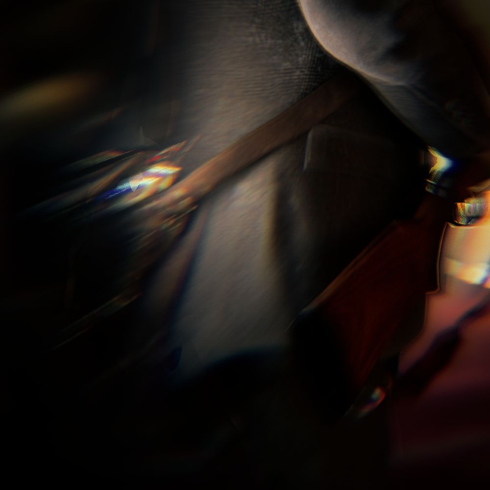 Virtual photography capture from Alan Wake 2. Alan Wake is viewed from behind, only his midsection from his elbow down to just below his coat hem is visible. The image is in color, with the lamp in Alan's satchel providing a gentle glow, showing the brown leather of the bag against the grey fabric of his coat. Alan is carrying a shotgun in the image, the stock of which is the only portion visible. In the background, a deep red carpet can be seen as well as a small amount of yellow wallpaper. The background is not only out of focus, but there is a heavy distortion across the entire image, giving it a dreamy effect opposite the clean look of the third image.