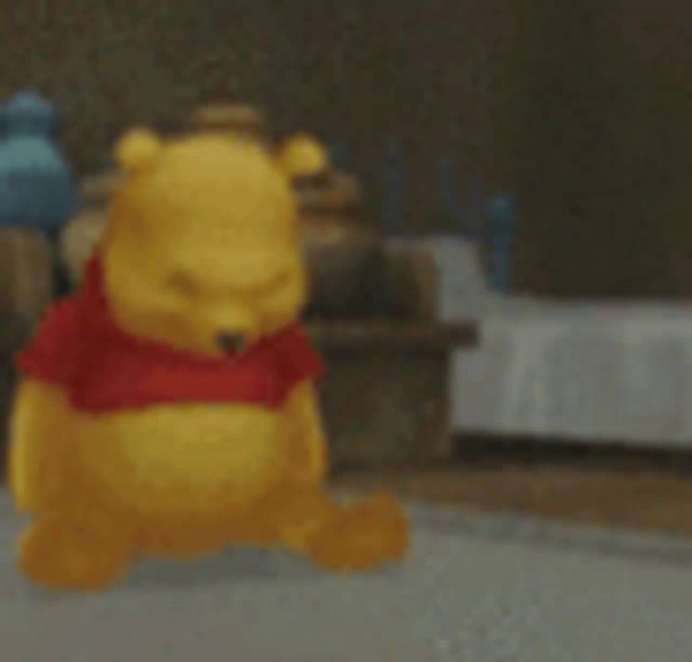 a winnie the pooh statue is sitting on the floor