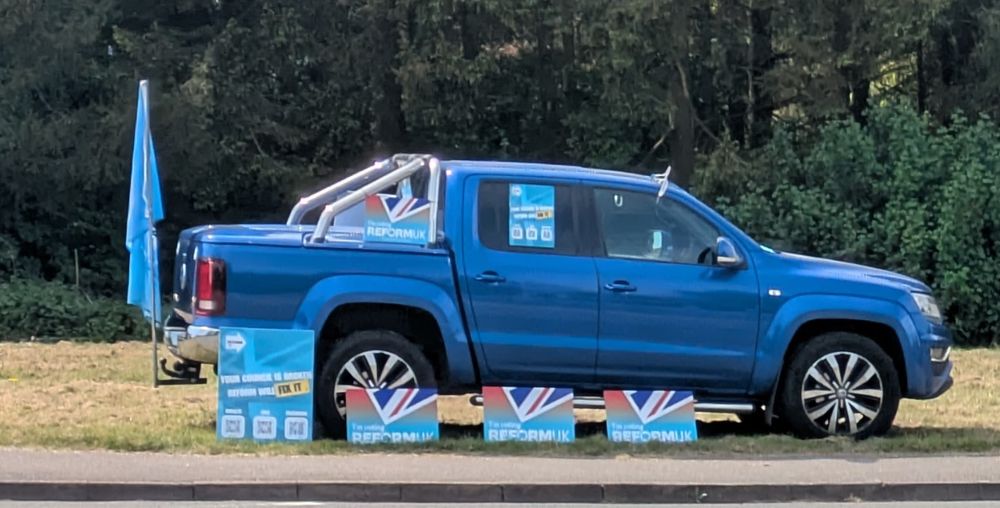 a VW pickup covered in Reform propaganda and flags that should get in the sea