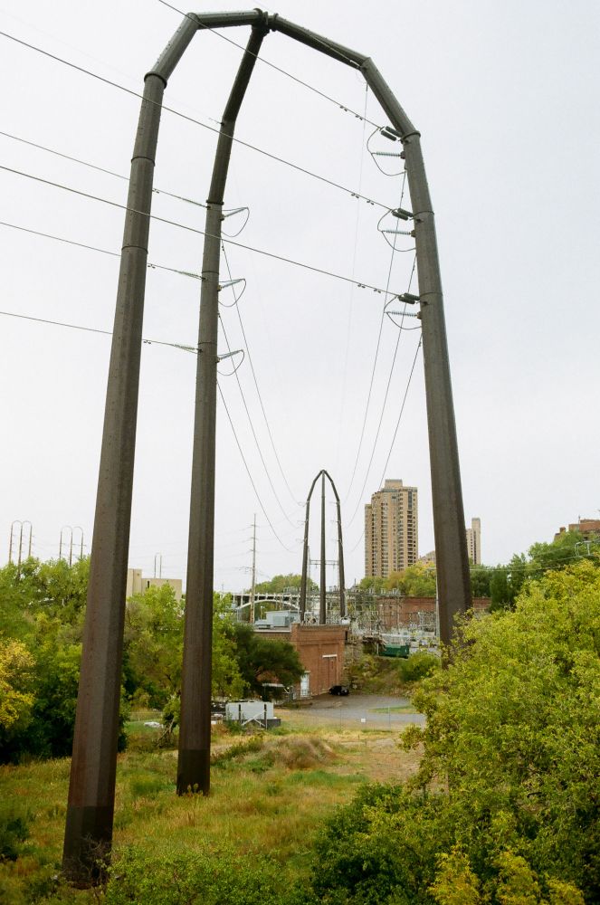 strange three-legged high tension wire towers in the middle of a forested downtown