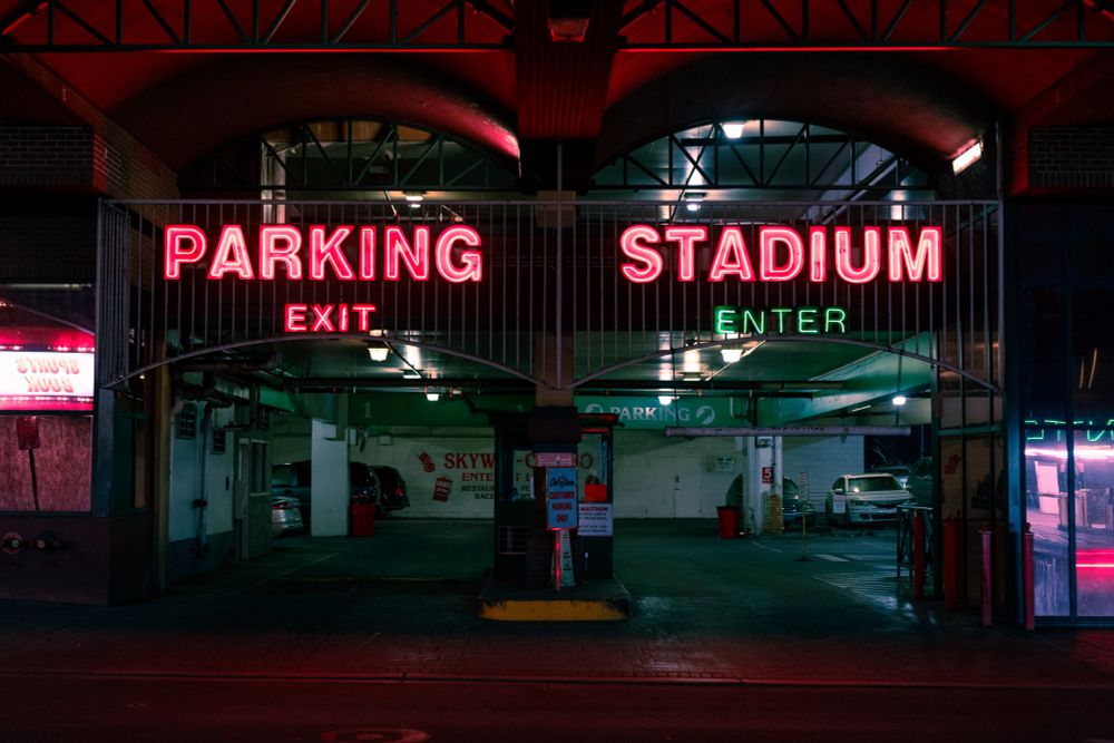 a garage with bright neon, in red, that says PARKING STADIUM 
below says EXIT and (lit green) ENTER