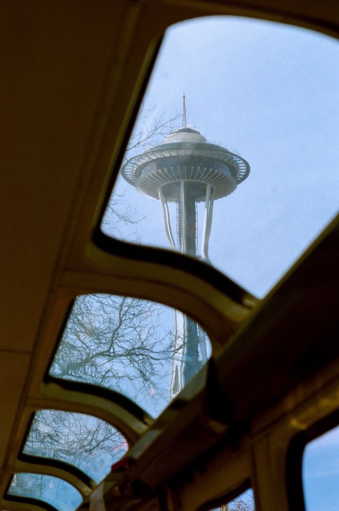 The space needle seen out the top windows of the monorail. 