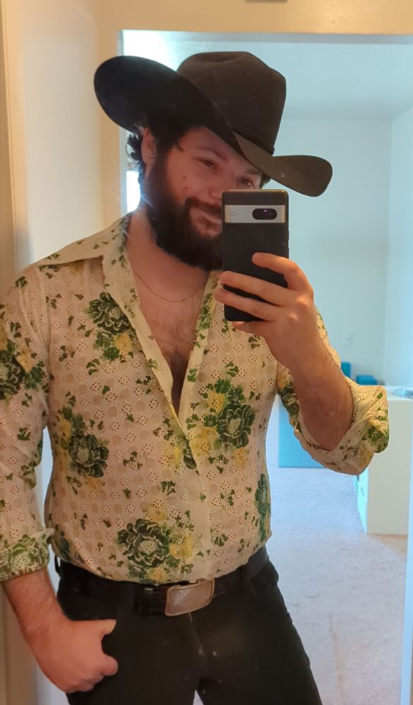 A closer look at the outfit in which the man is wearing a thin chain necklace