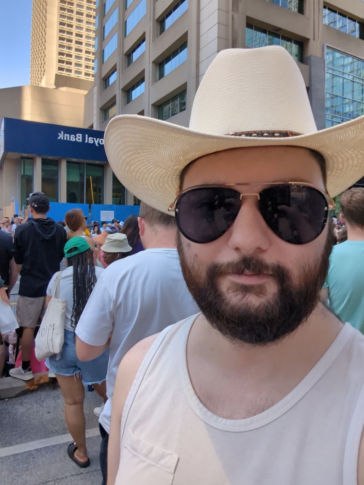 Me in my cowboy hat and aviators in the crowd before the Toronto pride parade begins
