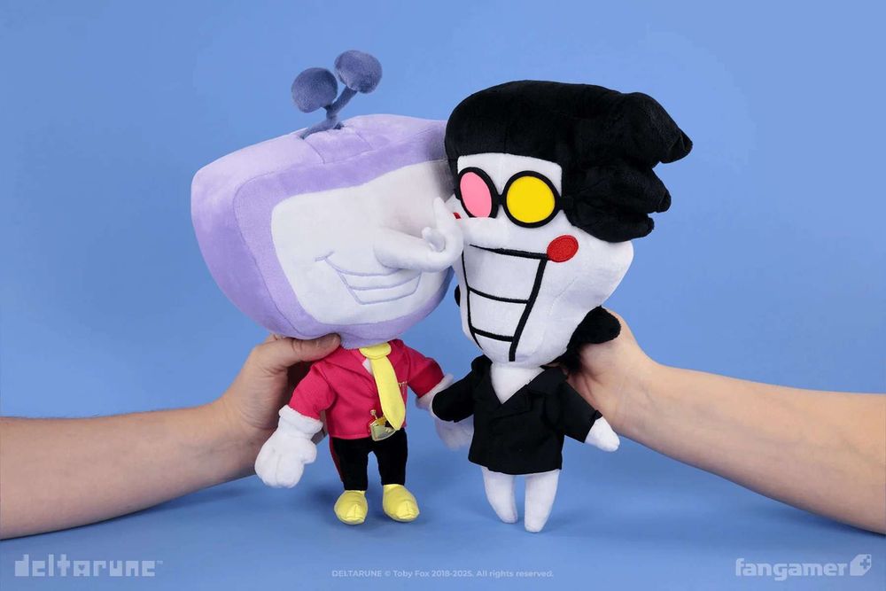a photo of the Tenna and Spamton plush from Fangamer, being held together, their noses tangled.