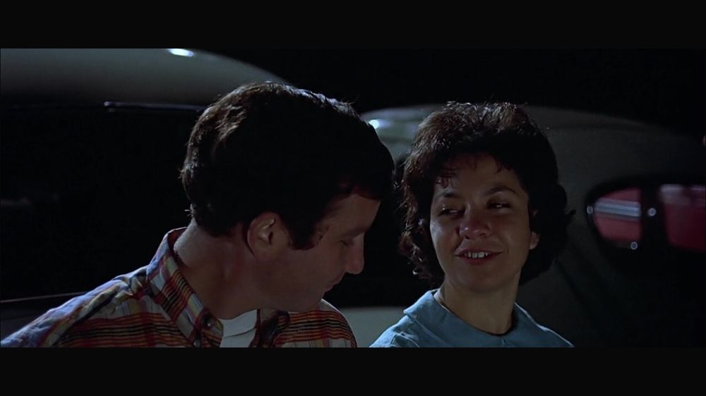 curt and debbie chatting in a parking lot (scene from movie American Graffiti)