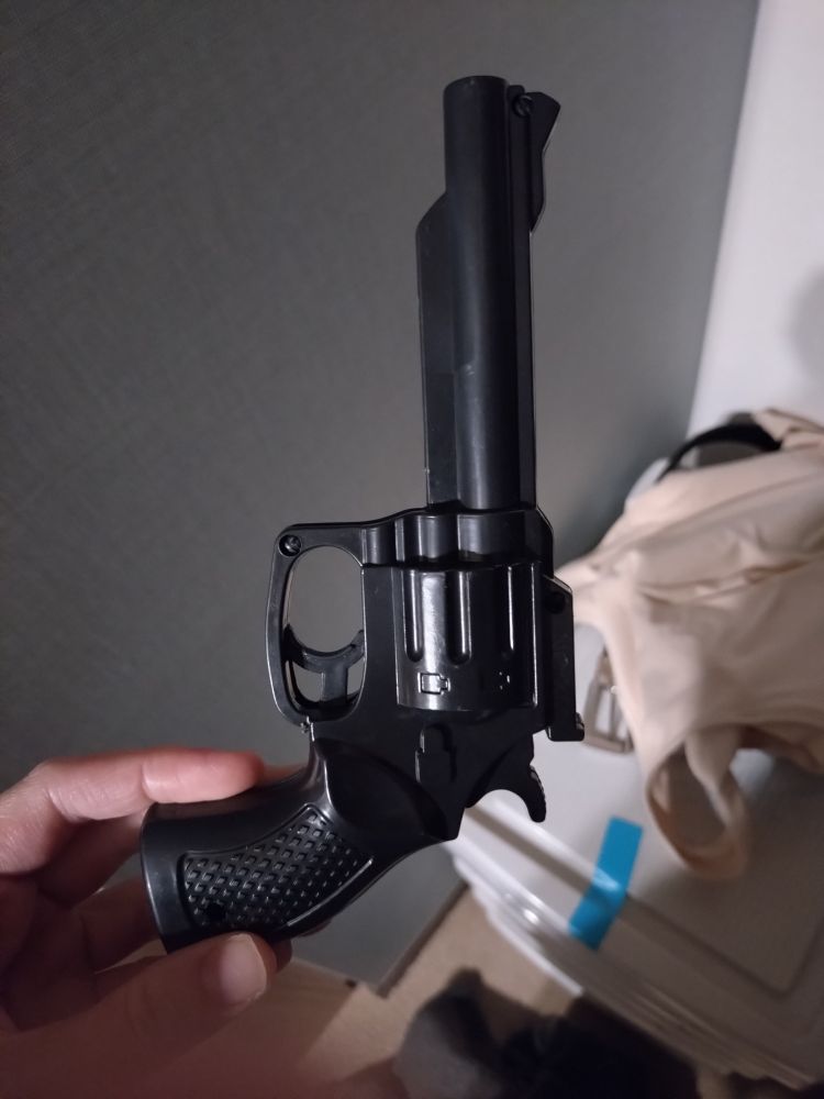 Replica de arma de ar de brinquedo muito semelhante a uma arma real de tambor da cor preta. 