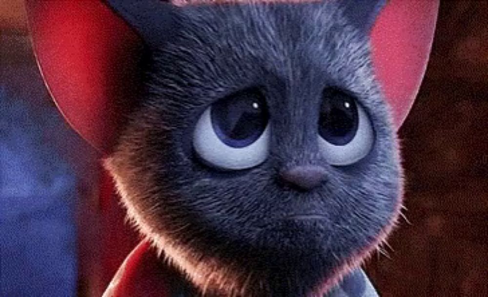 a close up of a cartoon cat with big blue eyes and red ears .