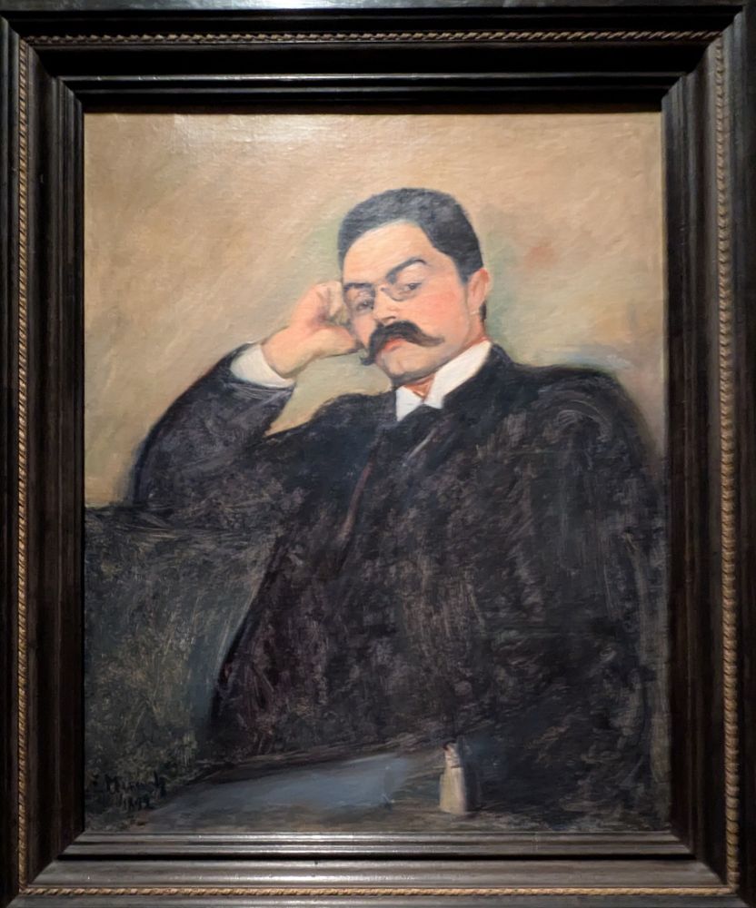 Painting of a man seated, resting his head on one hand. Gallery label: Thor Lütken

Oil on canvas, 1892

The lawyer, Thor Lütken (1863-1913), was a friend of Munch's, with whom he spent the summer months along the Oslo fjord. Munch painted this portrait to thank Lütken for his professional advice.

At first sight it appears to be simply a sympathetic portrait of a sophisticated man but, on close inspection, the sitter's sleeve along the bottom edge doubles up as a moonlit landscape inhabited by two mysterious figures who could be lovers, or a symbolic portrayal of life and death.

A picture-within-a-picture, it is something very unusual to find in a portrait and shows how open Munch was to Symbolist influences at this time.

Private Collection