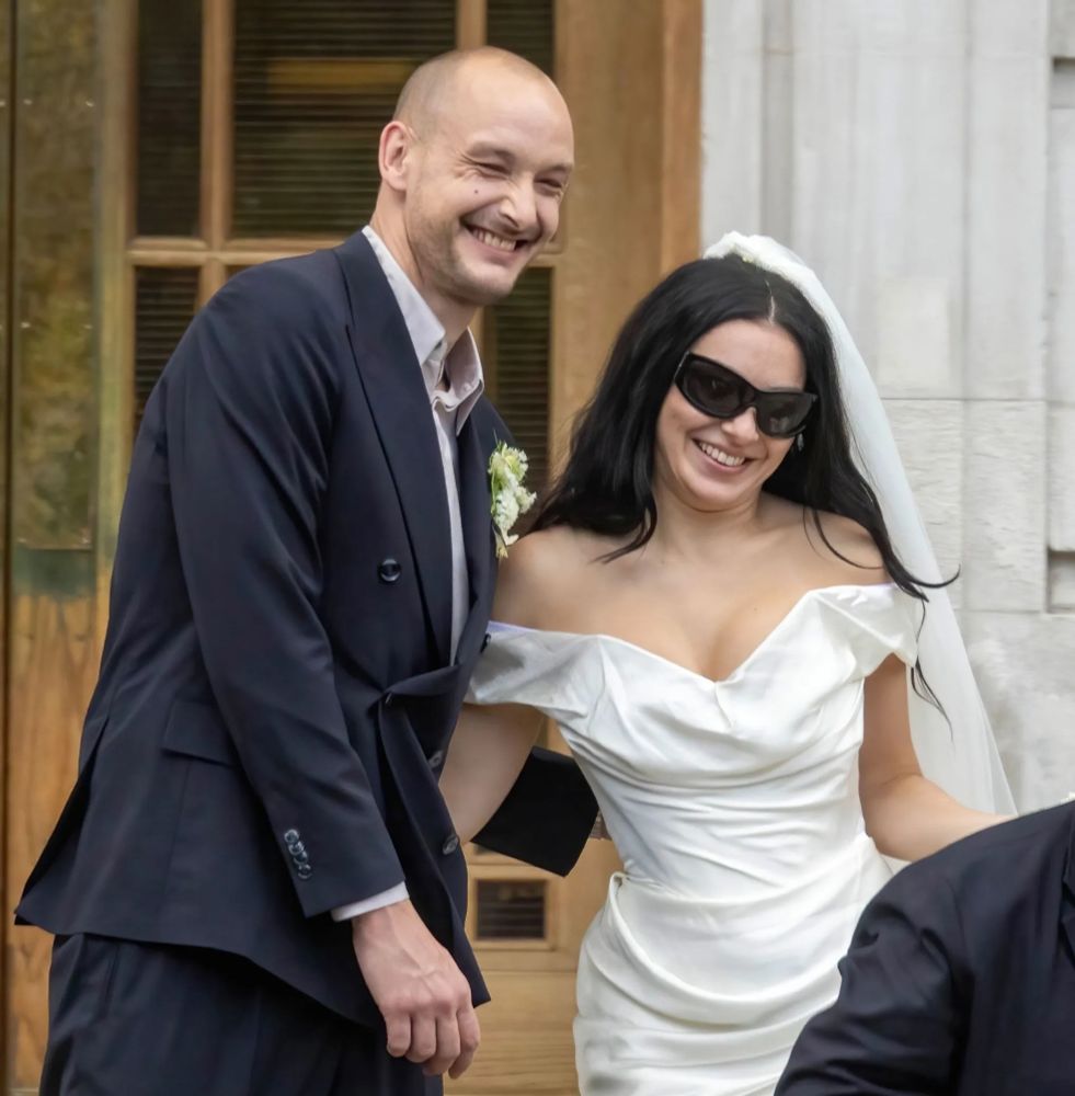 George Daniel and Charli xcx at their wedding in London on July 19, 2025. Charli wears her classic brat sunglasses and Vivienne Westwood gown. 

Click News and Media / BACKGRID