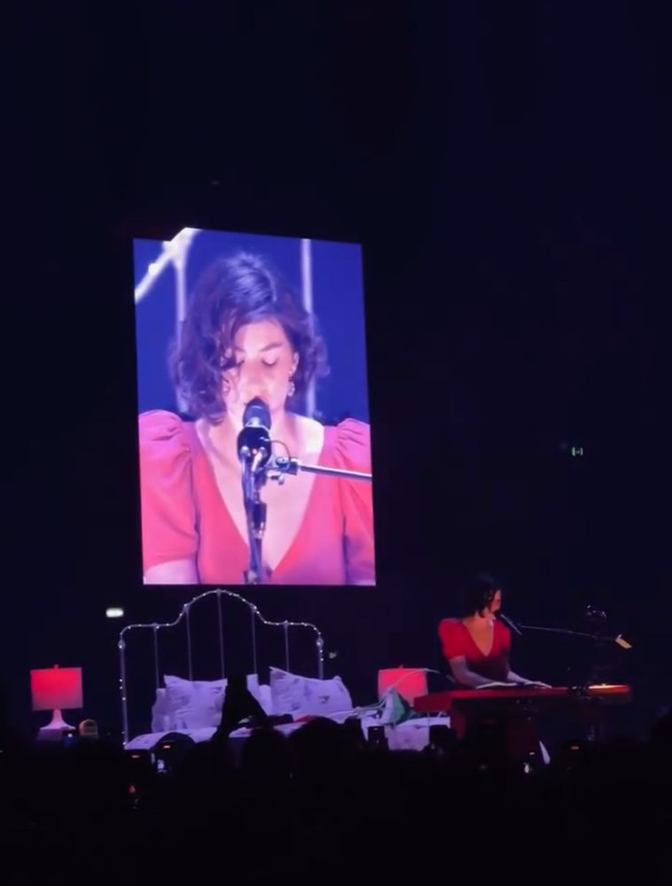 Gracie singing in a red dress on stage. 