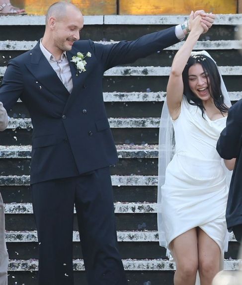 George Daniel and Charli xcx at their wedding in London walking down the steps on July 19, 2025.
BACKGRID