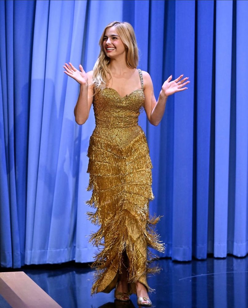 Addison Rae arriving to Fallon in a gold column gown.