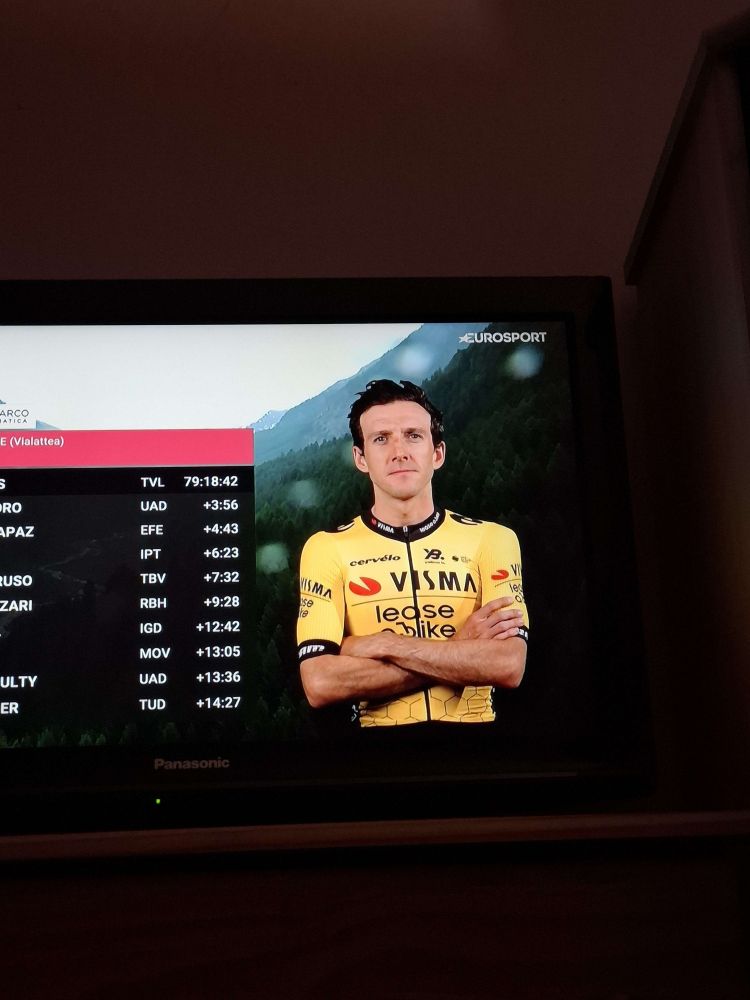 A photo of Simon Yates' giro headshot next to the GC top10 overlay. Simon crossed arms and a surly face and resembles the drawing of the honey badger.