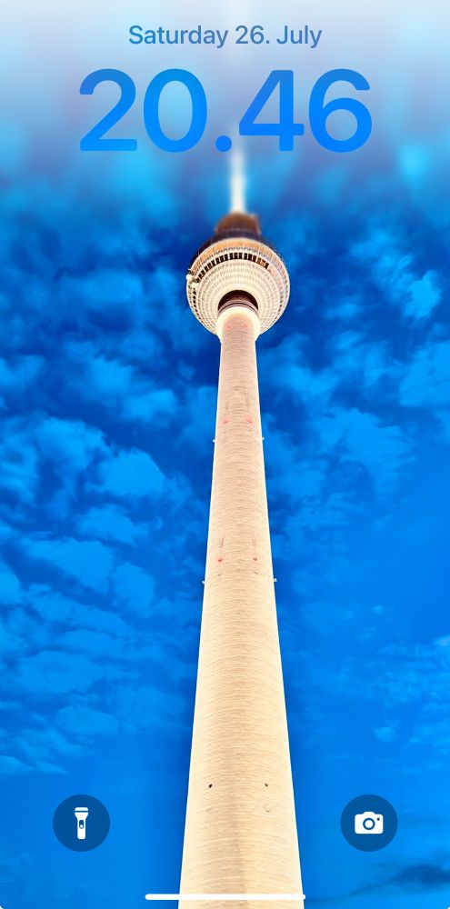 iOS Lock Screen featuring the Berlin TV Tower against a blue night sky.