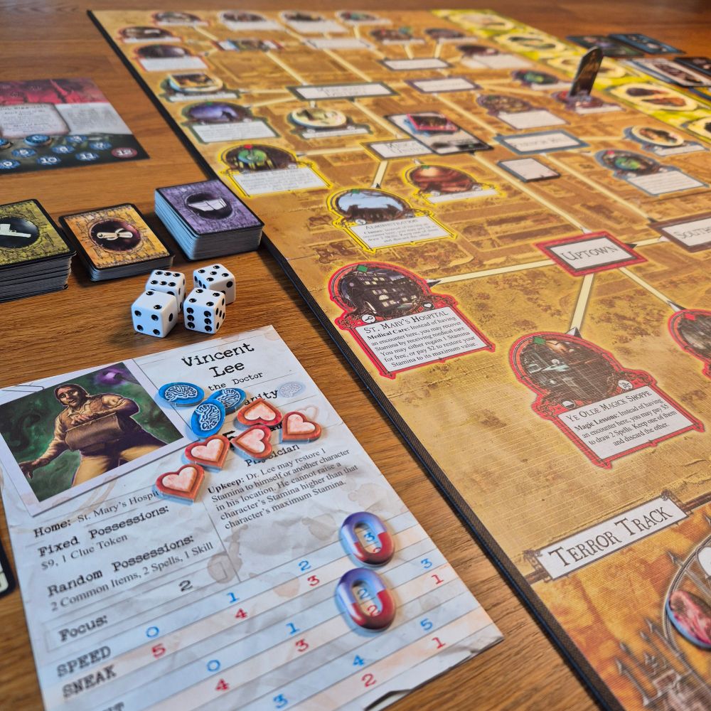A game of Arkham Horror. Board visible and a character sheet for Vincent Lee, the doctor, along with dice and some cards.