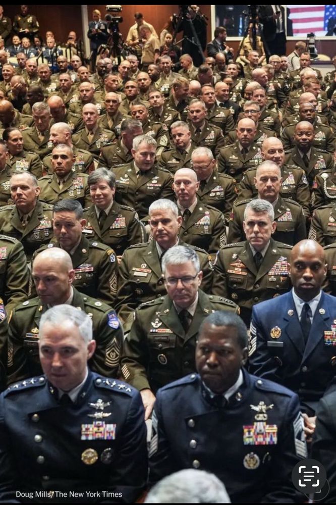Picture of U.S. generals and Admirals sitting stoically while a drunk and a felon lecture to them about military standards. 