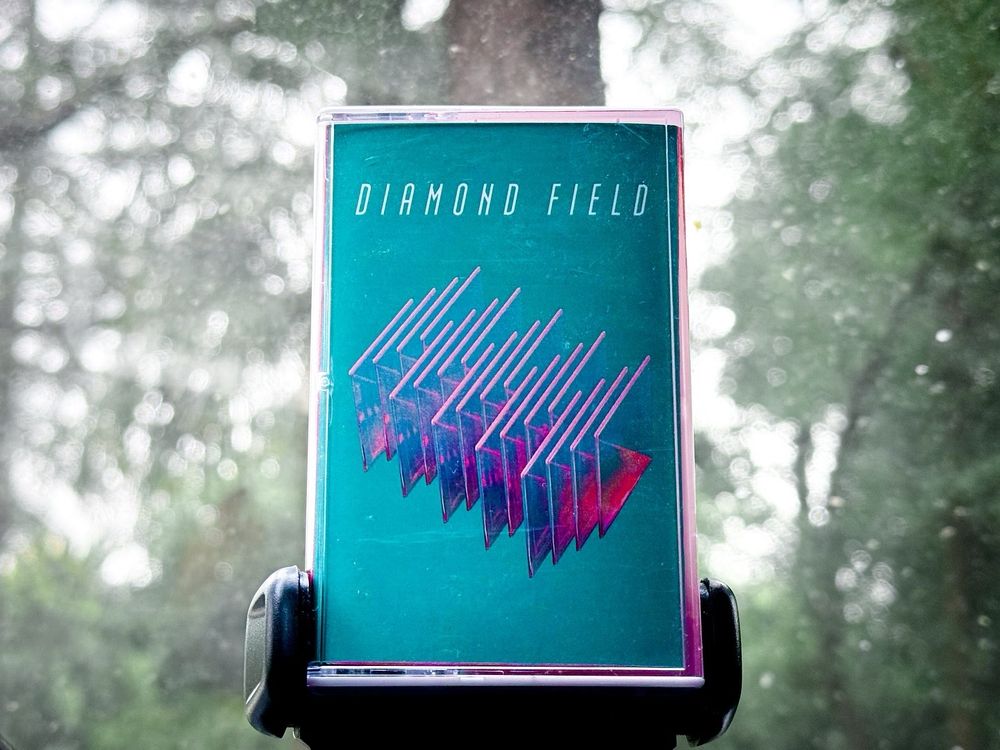 cassette case for Diamond Field tape, on the dashboard of a car
