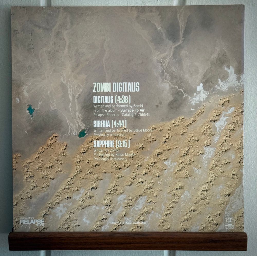 Back cover of Zombi Digitalis LP - an aerial shot of a barren landscape, and track listing (Digitalis, Siberia, Sapphire)
