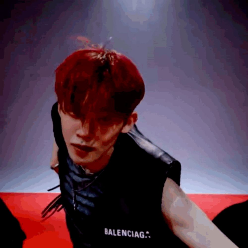 a young man with red hair is wearing a black balenciaga vest