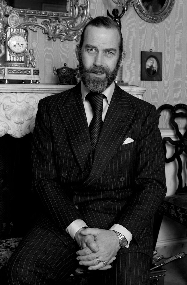 Prince Michael of Kent wearing a striped double-breasted suit with a tie knot that's perhaps a third of the size of his head. 