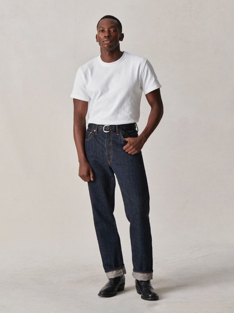 Man in a pair of Buck Mason saddle cut jeans. 
