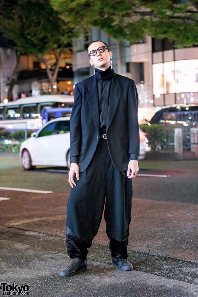 A young man in Harajuku wearing an oversized black suit (maybe by Yohji Yamamoto)