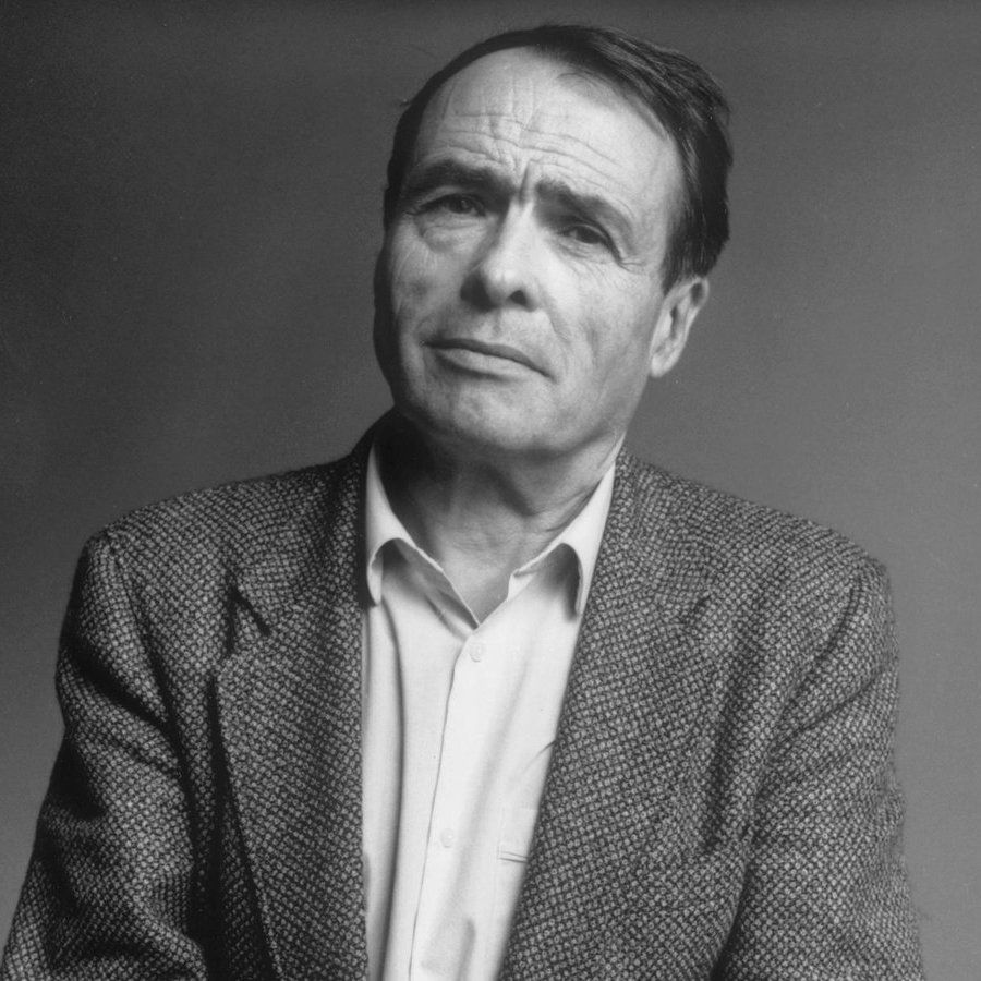 Portrait of Pierre Bourdieu. He's wearing a tweed single-breasted jacket with a light-colored dress shirt. No tie. 