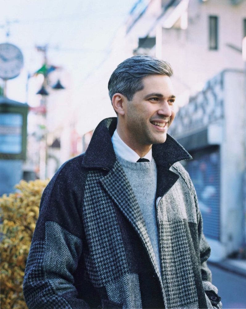 The author David Marx wearing a grey patchwork overcoat and grey Shetland sweater. 