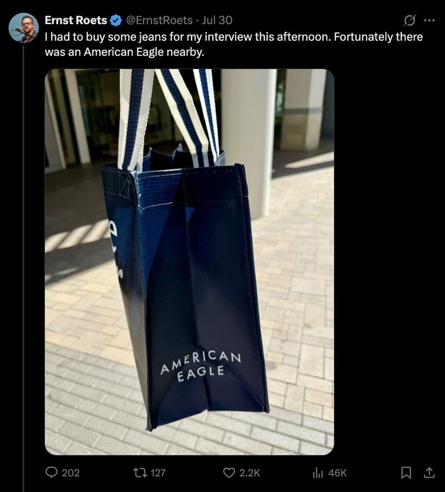 A man walks around with an American Eagle shopping bag. 