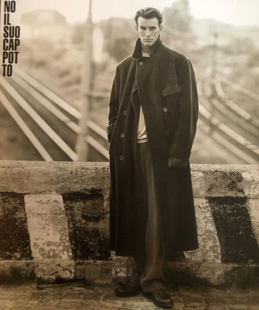 A man in a big double-breasted overcoat. 