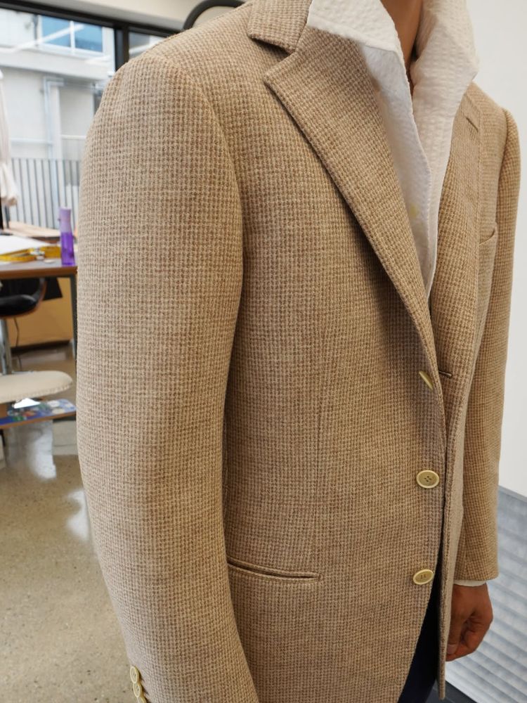 The front of the tweed jacket on the wearer. The lapel has a lot of curvature. 
